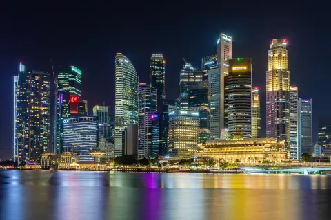 Singapore central business district skyscrapers lit up at night across Marina Bay